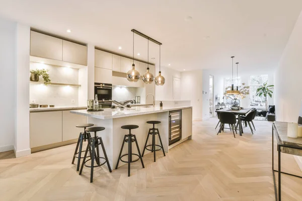 ミニマリストスタイルのオープンキッチンとテーブルと椅子付きの広々としたダイニングゾーンとモダンなロフトアパートのホームインテリアデザイン — ストック写真
