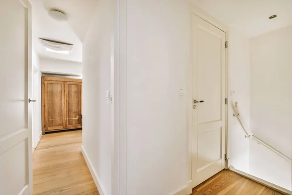 廊下の隣にある部屋の白い扉と家の階段の上にあるスタイリッシュなランプ — ストック写真