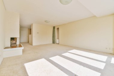 Balkon kapısı ve pencerelere karşı şöminesi ve zarif avizesi olan ferah ışık odasının içi