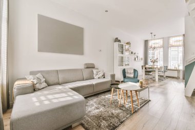 Çağdaş dairenin pencerelerine karşı rahat kanepesi ve televizyonu olan oturma odası.