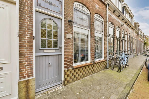 Front View Brick Building Signs Cars Pavement Wooden Doors Lead — Fotografie, imagine de stoc