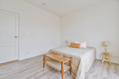 Rahat yatak ve geniş yatak odasında yumuşak halı. İç dekorasyonu çok az.