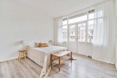 Rahat yatak ve geniş yatak odasında yumuşak halı. İç dekorasyonu çok az.