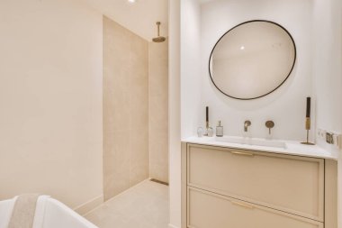 Aynalı lavabo ve temiz küvet modern banyoda beyaz fayanslı duvarları olan duş kutusunun yanında.