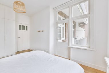 Yatak odasının iç dizaynı, yatak odası ve ahşap gardırop modern apartmanın balkon kapısının yanında.