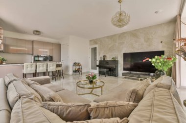 Beyaz dolaplar, ahşap mutfak tezgahı ve oturma odasında yemek masası.