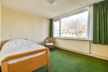 Yatak odasının iç tasarımı, yatak odası ve ahşap gardırop modern dairenin penceresinin kenarına yerleştirilmiş.