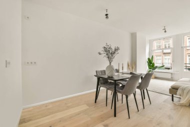 Modern apartmandaki dekorasyonlu ve televizyonlu, rahat koltuğun yanına yerleştirilmiş eski püskü ahşap masa.