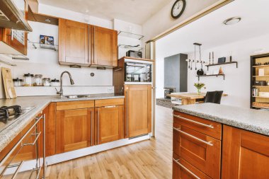 Modern bir evdeki yemek alanının yanındaki kahverengi dolaplı bir ev mutfağının modern iç tasarımı.