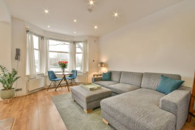 TV 'nin yanındaki koltuklar ve masa, çağdaş apartmandaki geniş odalı yemek alanına karşıdır.