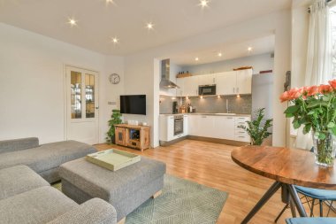 TV 'nin yanındaki koltuklar ve masa, çağdaş apartmandaki geniş odalı yemek alanına karşıdır.