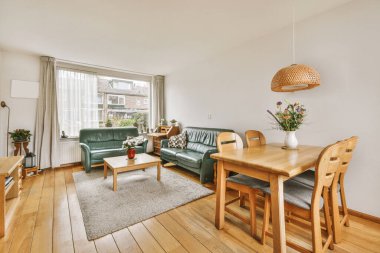 TV 'nin yanındaki koltuklar ve masa, çağdaş apartmandaki geniş odalı yemek alanına karşıdır.