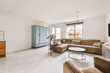 Çağdaş açık mutfak, yemek masası seti ve ferah odada gri kanepe.