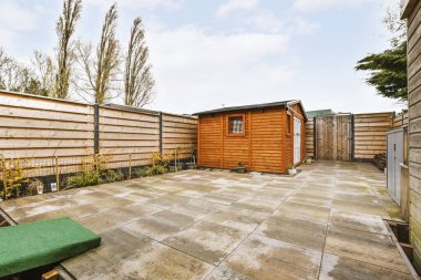 Spacious garage with closed white door and wooden walls with hangers on it