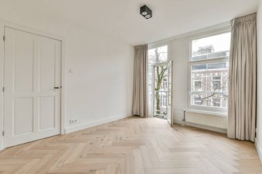 Evdeki boş ışık odasında, beyaz duvardaki plastik pencere ve radyatör.