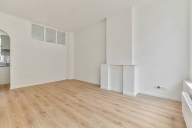 Evdeki boş ışık odasında, beyaz duvardaki plastik pencere ve radyatör.