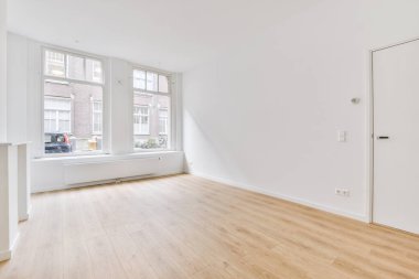 Evdeki boş ışık odasında, beyaz duvardaki plastik pencere ve radyatör.