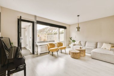 TV 'nin yanındaki koltuklar ve masa, çağdaş apartmandaki geniş odalı yemek alanına karşıdır.