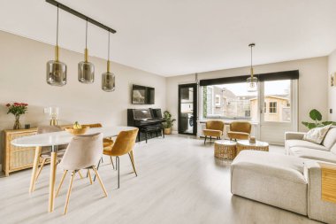 TV 'nin yanındaki koltuklar ve masa, çağdaş apartmandaki geniş odalı yemek alanına karşıdır.