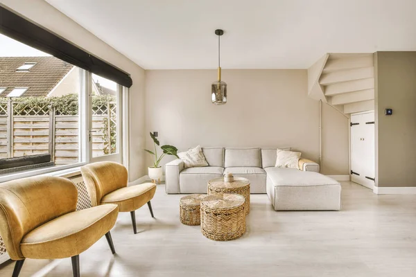 TV 'nin yanındaki koltuklar ve masa, çağdaş apartmandaki geniş odalı yemek alanına karşıdır.