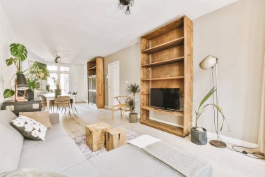 TV 'nin yanındaki koltuklar ve masa, çağdaş apartmandaki geniş odalı yemek alanına karşıdır.