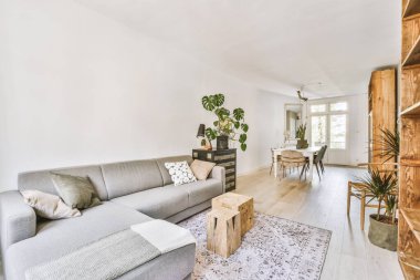 TV 'nin yanındaki koltuklar ve masa, çağdaş apartmandaki geniş odalı yemek alanına karşıdır.