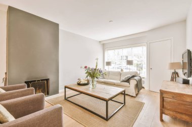 Çağdaş açık mutfak, yemek masası seti ve ferah odada gri kanepe.