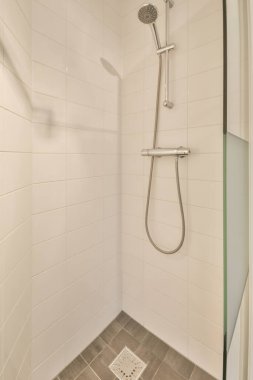 Duşu olan ve düz bir şekilde lavaboya batan çağdaş bir banyo.