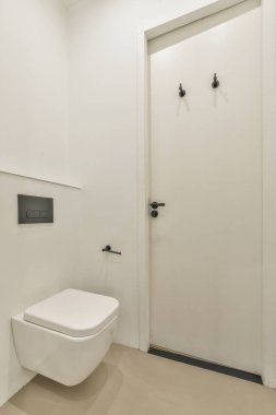 Tuvaleti duvara asılmış beyaz fayanslı banyoda lavabo ve ayna dolabı.