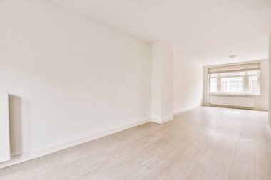 Evdeki boş ışık odasında, beyaz duvardaki plastik pencere ve radyatör.