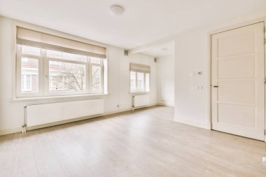 Evdeki boş ışık odasında, beyaz duvardaki plastik pencere ve radyatör.