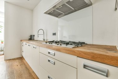 Modern mobilyalar ve aletlerle mutfak yakınında bulunan şömineli ve zarif avizeli ferah hafif yemek odasının içi.