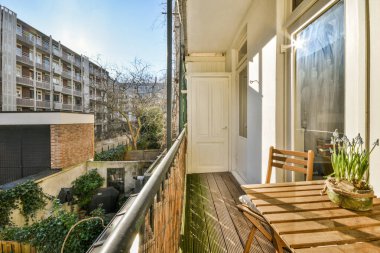 Eski tuğla binaların panoramik manzarası. Küçük balkondan park yerleri ve ağaçlar.