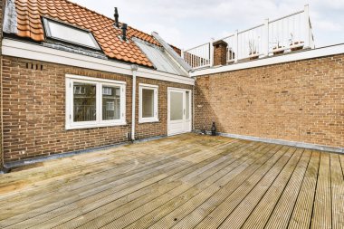 Parlak tuğlalı balkon, metal parmaklıklar ve kapı.