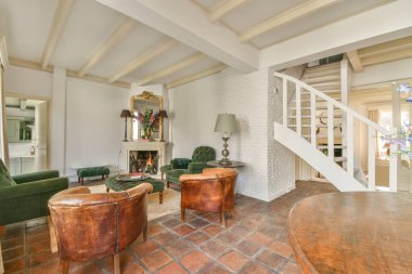 Çağdaş açık mutfak, yemek masası seti ve şömineli gri kanepe.