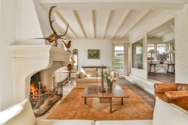 Çağdaş açık mutfak, yemek masası seti ve şömineli gri kanepe.