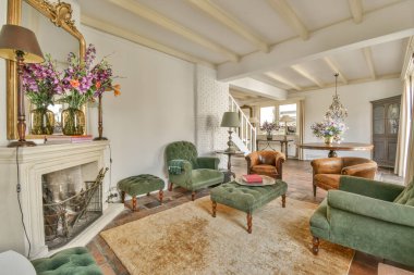 Çağdaş açık mutfak, yemek masası seti ve şömineli gri kanepe.