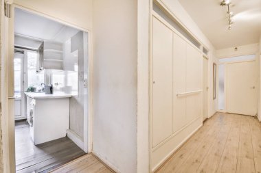 Minimalist tarzı beyaz mobilyalı, lavabolu ve sobalı bir ev mutfağı.