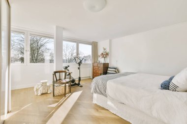 Yatak odasının iç tasarımı, yatak odası ve ahşap gardırop modern dairenin penceresinin kenarına yerleştirilmiş.