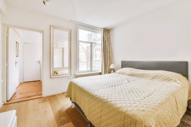 Yatak odasının iç tasarımı, yatak odası, televizyon ve ahşap gardırop modern apartmanın penceresinin kenarına yerleştirilmiş.