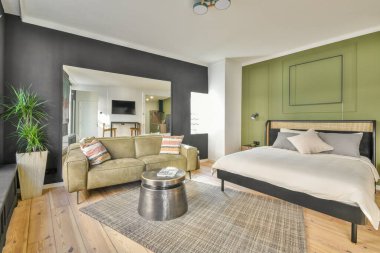 Renkli yastıkları olan rahat bir yatak ve pencerenin yanındaki yeşil duvarlı şık yatak odasında sıcak bir battaniye.