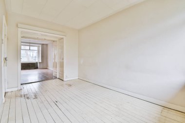 Evdeki boş ışık odasında, beyaz duvardaki plastik pencere ve radyatör.