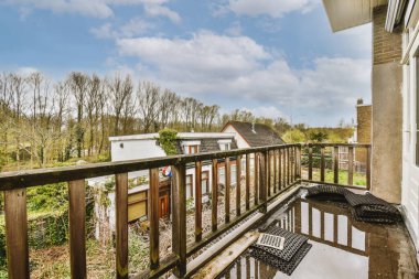 Dar tuğlalı balkon, ahşap parmaklıklar ve kapı.