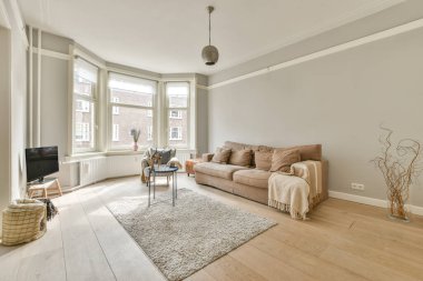 Sandalyeli masa ve rahat kanepe modern dairede şık dekorasyonlarla dolu geniş bir odada.