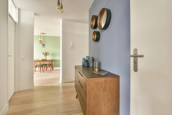 Stylish hallway with door and window to light dining room in modern house