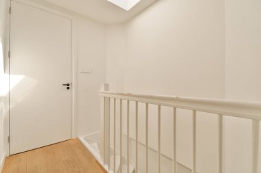 Evin koridorundaki oturma odasına açılan merdiven ve kapının yanındaki dekorasyon ve aynalı retro dolap.