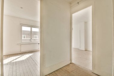 Evdeki boş ışık odasında, beyaz duvardaki plastik pencere ve radyatör.