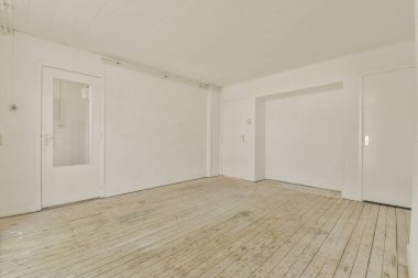 Büyük balkon pencereli, perdeli ve ahşap parke zeminli boş beyaz odanın içi.