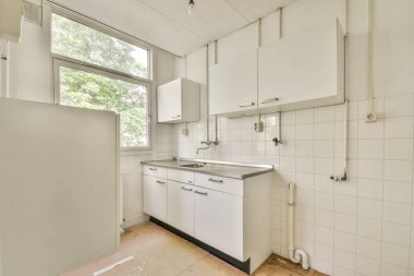 Minimalist stil mutfak, basit dolaplar ve aydınlık dairede modern aletler.