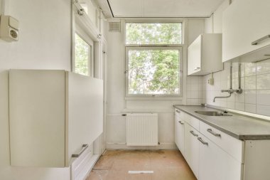 Minimalist stil mutfak, basit dolaplar ve aydınlık dairede modern aletler.